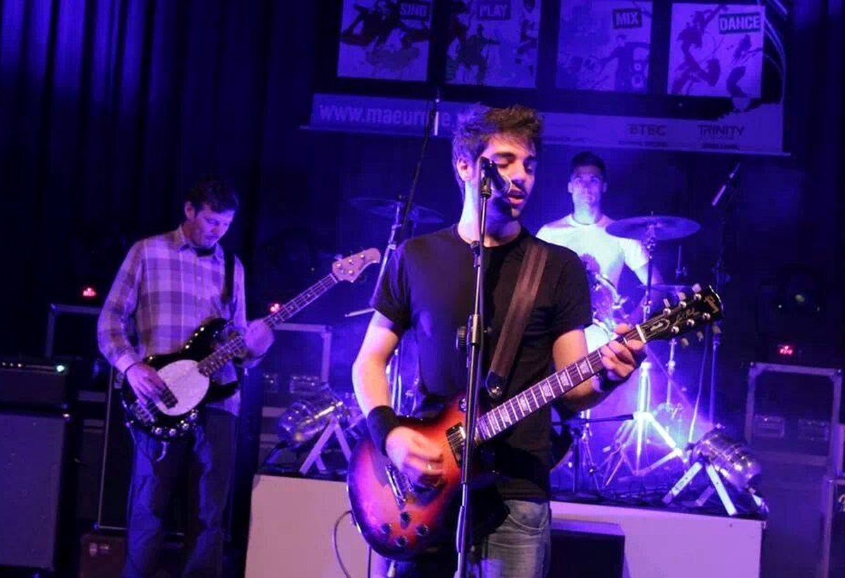 Live band performance on stage under purple lighting