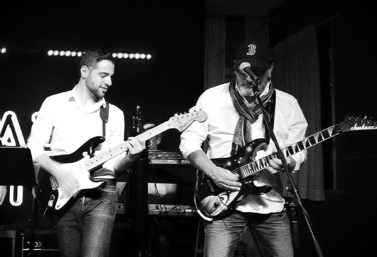 Two electric guitarists performing together on stage